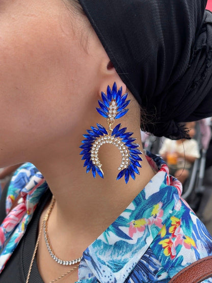 Close up ear with blue fancy geometric peacock feather shape dangle drop fashion jewelry earrings with rhinestones - Roulette Safari