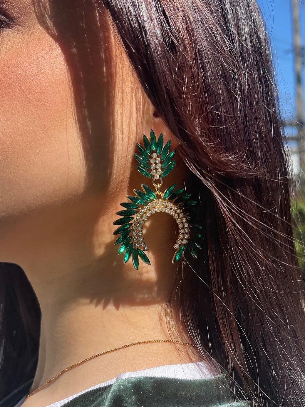 Close up ear with green emerald fancy geometric peacock feather shape dangle drop fashion jewelry earrings with rhinestones - Roulette Safari